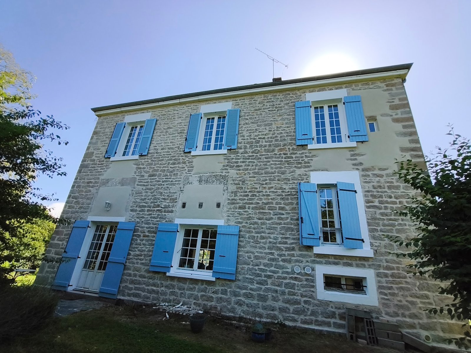 Façade en pierre avec boiseries extérieures repeintes